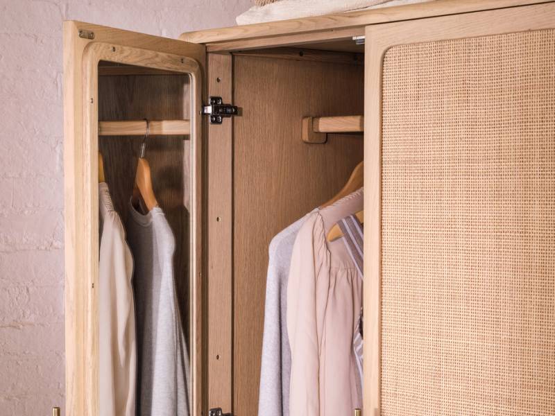 Coco wardrobe with clothes in it and a mirror