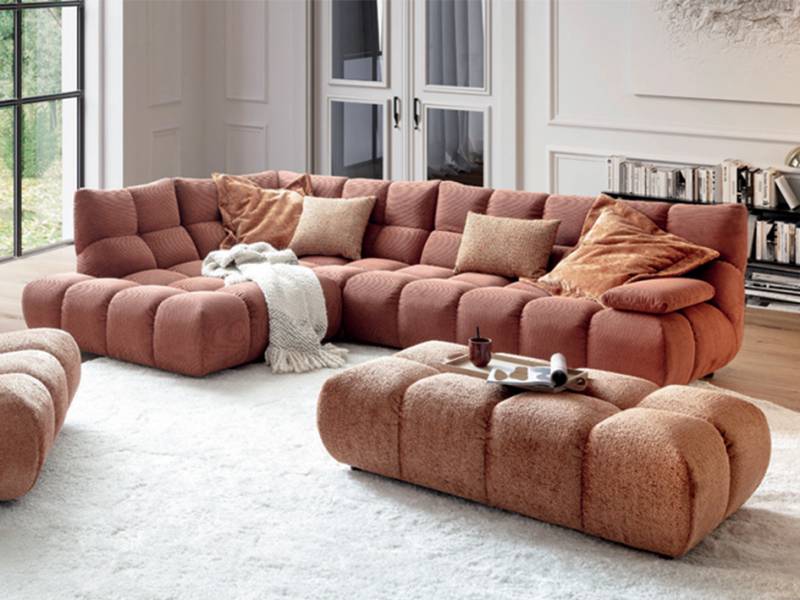 Gloria Corner Sofa in a living room with a big long poof
